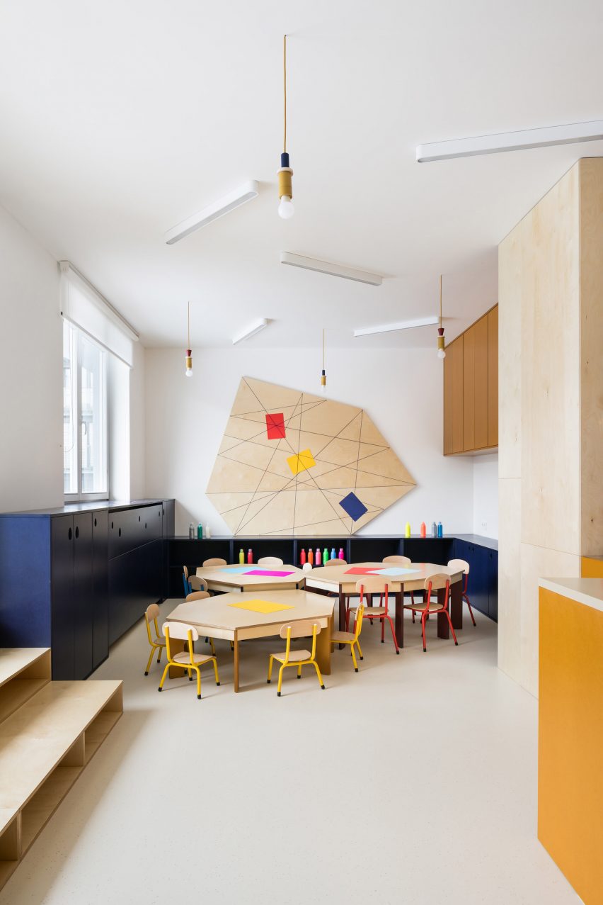 Different sized tables in drawing area of Prague kindergarten by No Architects
