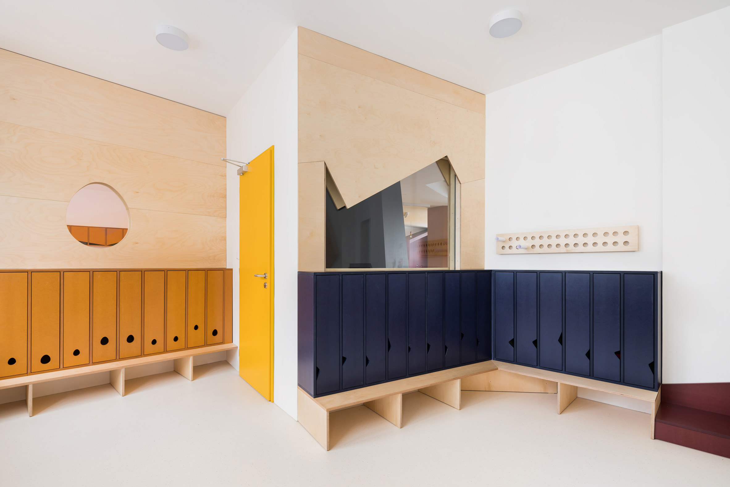  Dressing space with mustard yellow and navy blue lockers in Malvína Day Nursery