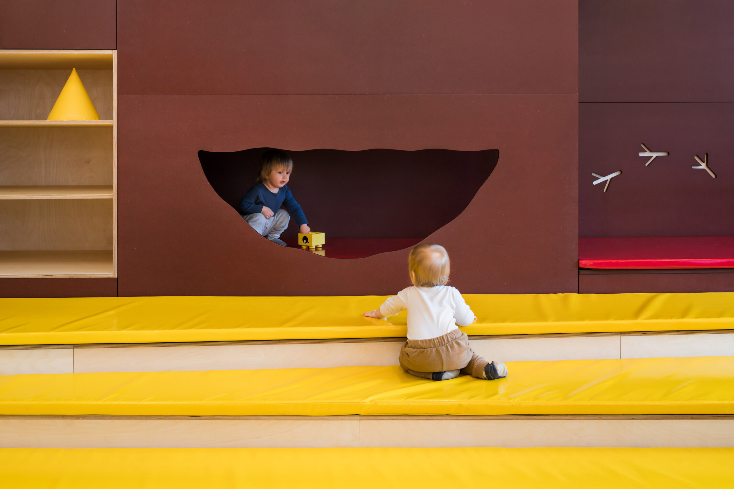  Stepped backyard with yellow matts and brown nook in Prague kindergarten by No Architects