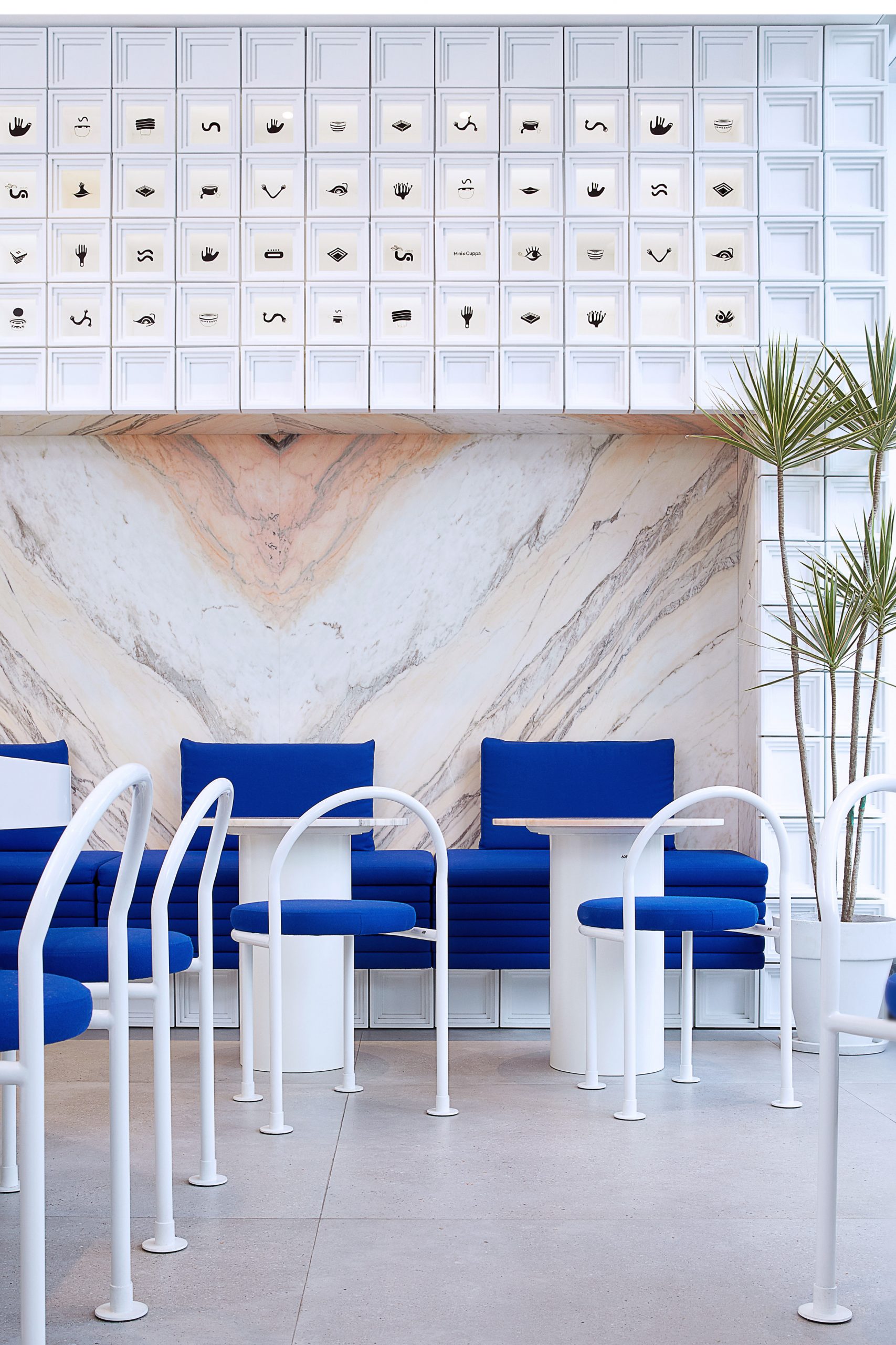 Marble panelling and white MDF blocks in seating area of Mini Cuppa cafe
