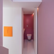 Pink hued walls line the stairwell