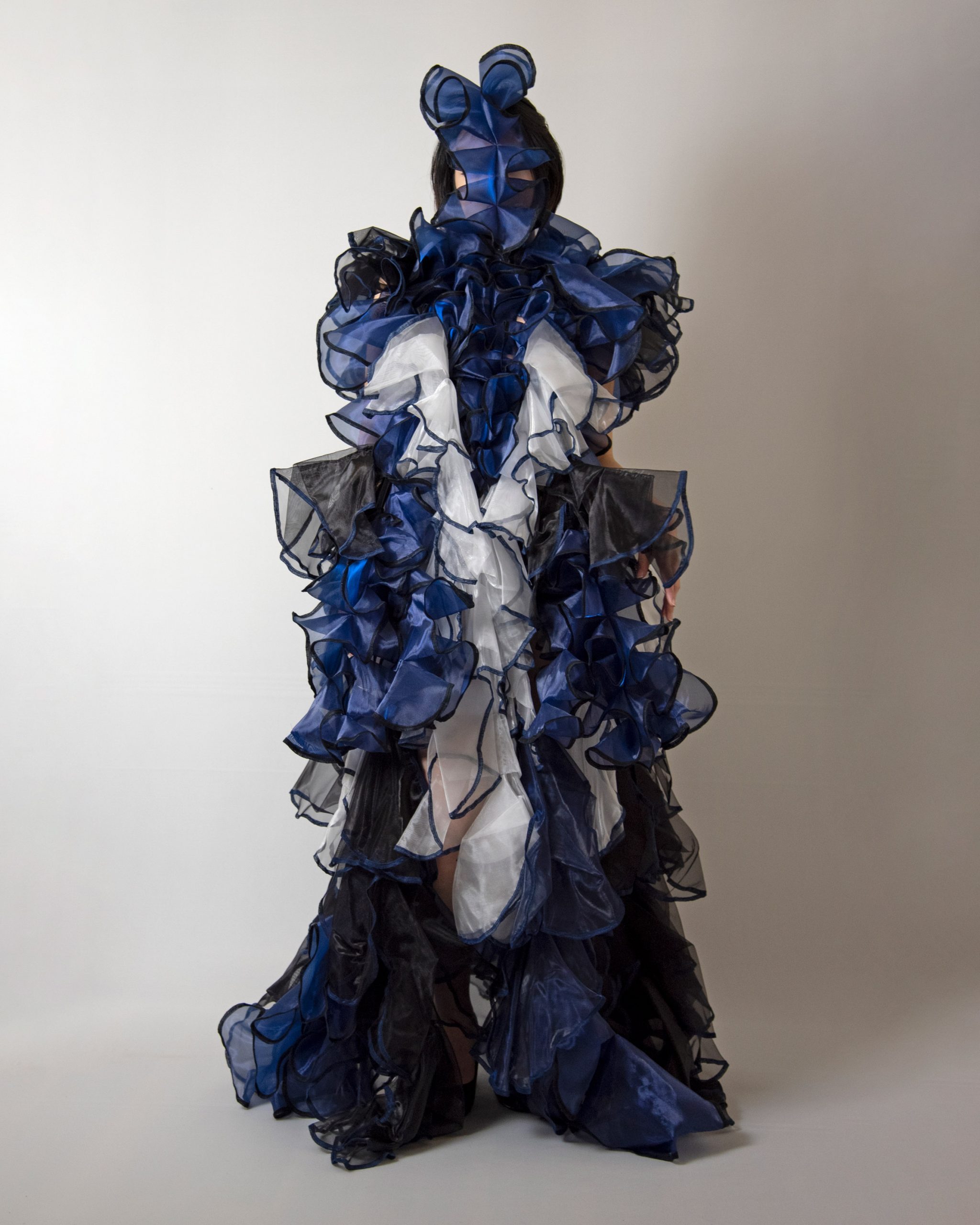 The garment is constructed using blue, white and black fabric by Ryunosuke Okazaki