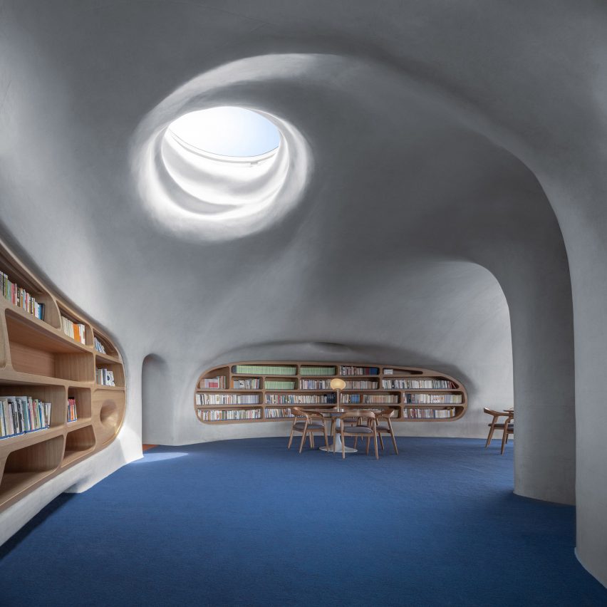 A concrete library lit by a skylight
