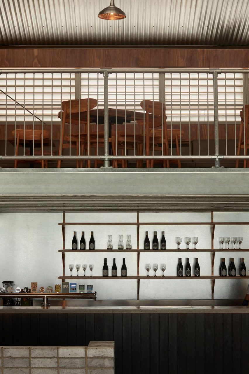 Charred wood panelled bar and steel-framed mezzanine in Melbourne Urbnsurf restaurant