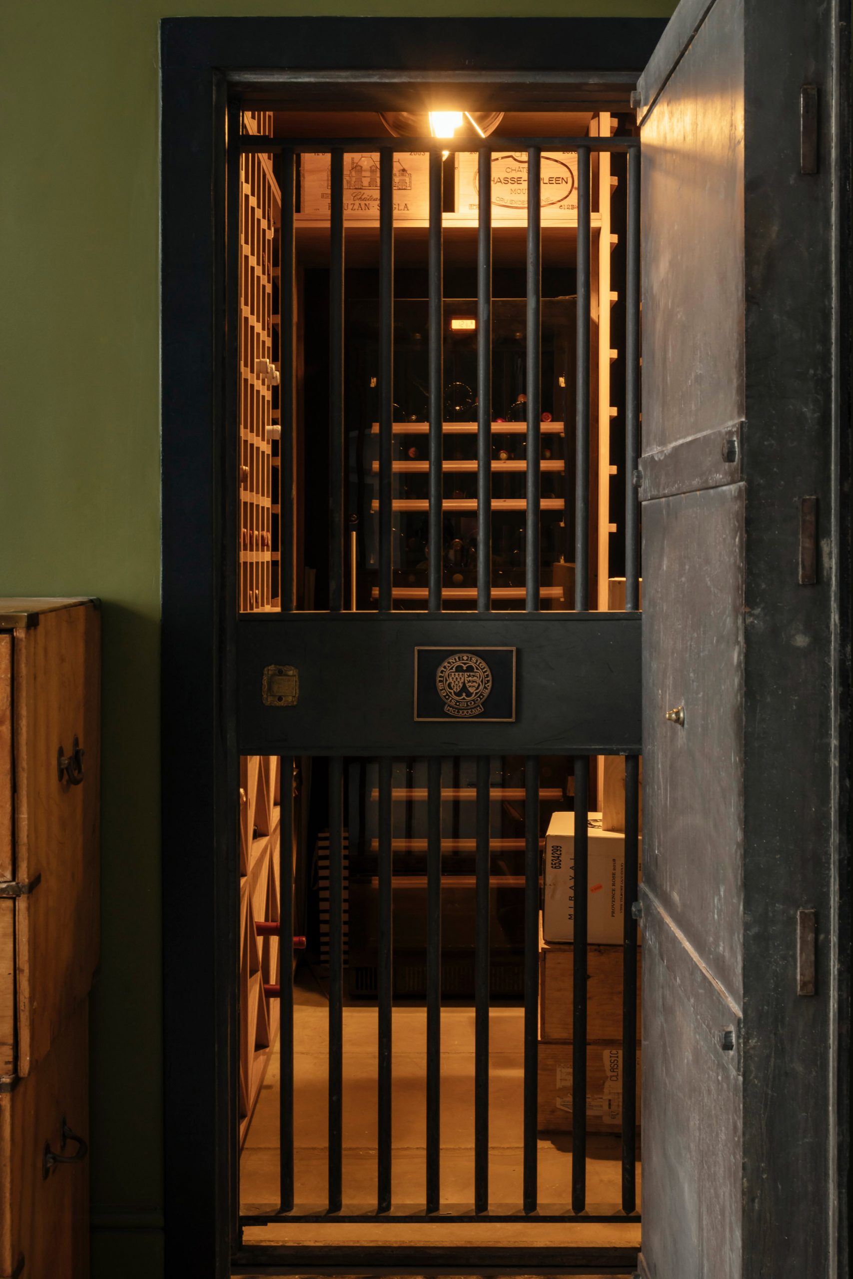 Vault door leading to wine cellar in London apartment by Daab Design