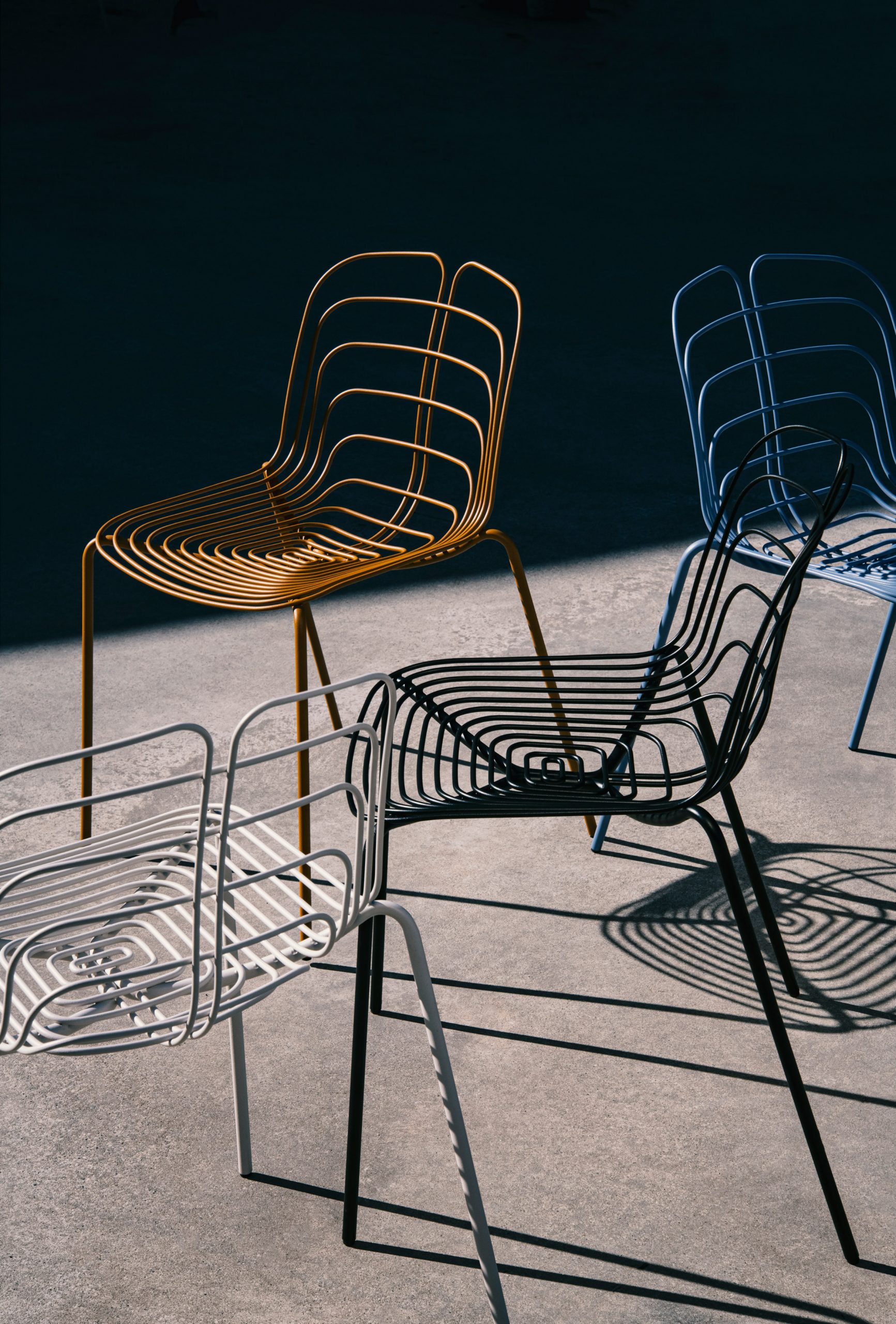 Four Wired chairs in white, black, blue and bronze