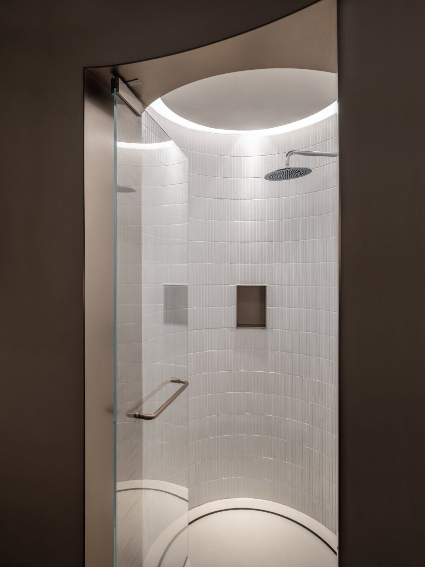 A glass door leads to a walk-in shower 