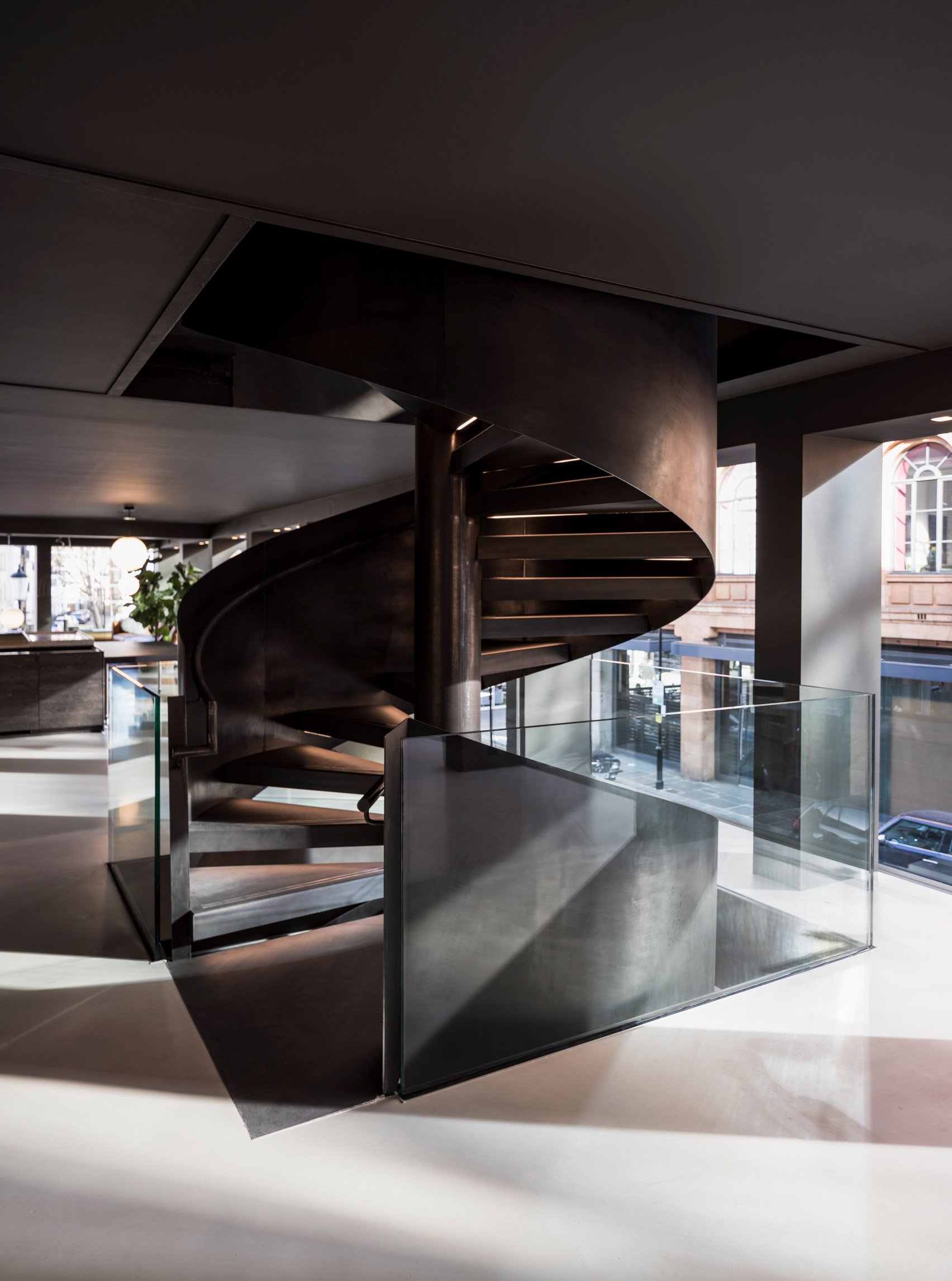 Helical spiral staircase clad in metal in a London furniture showroom