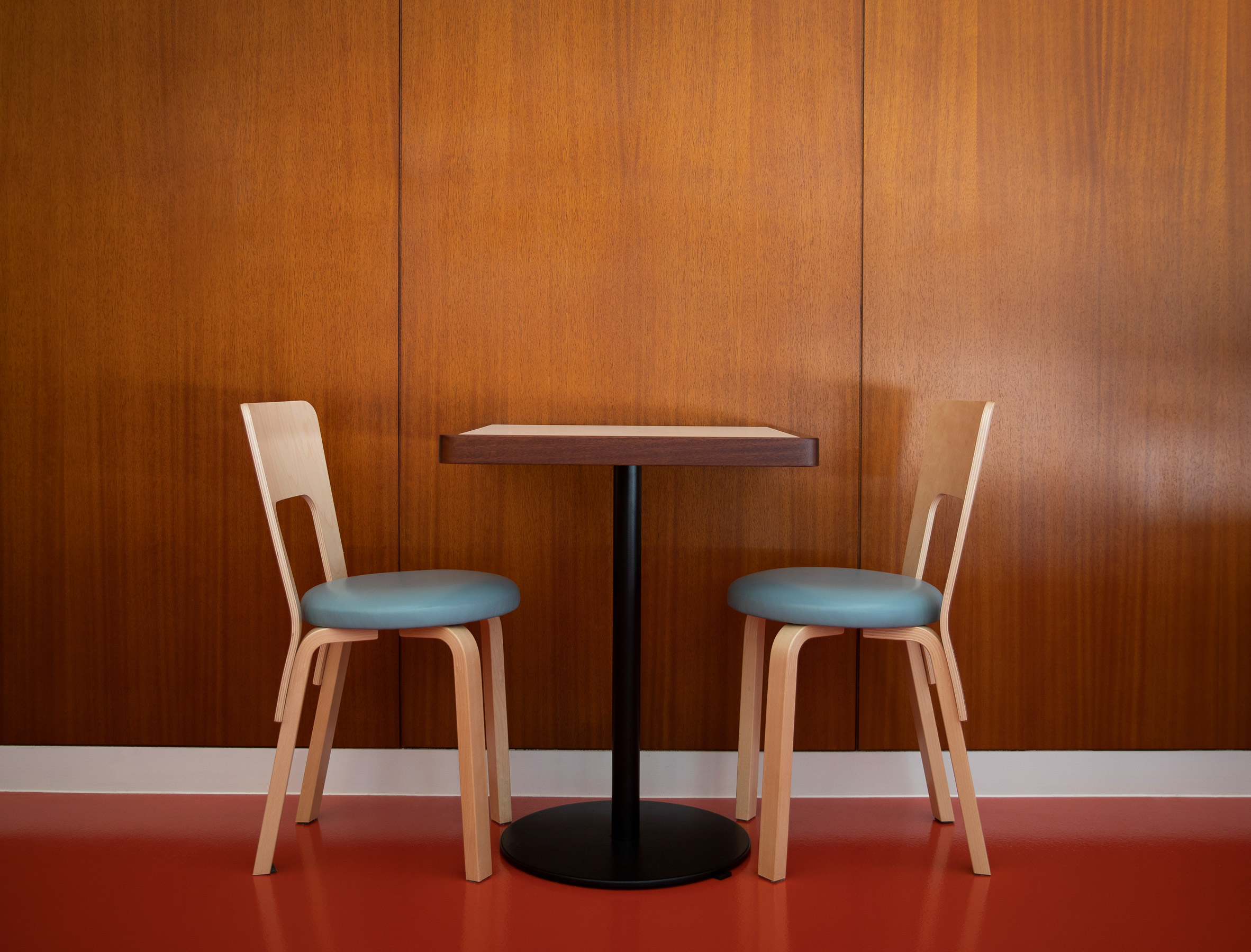 Dining chairs against wood-panelled walls in Cafe Bao