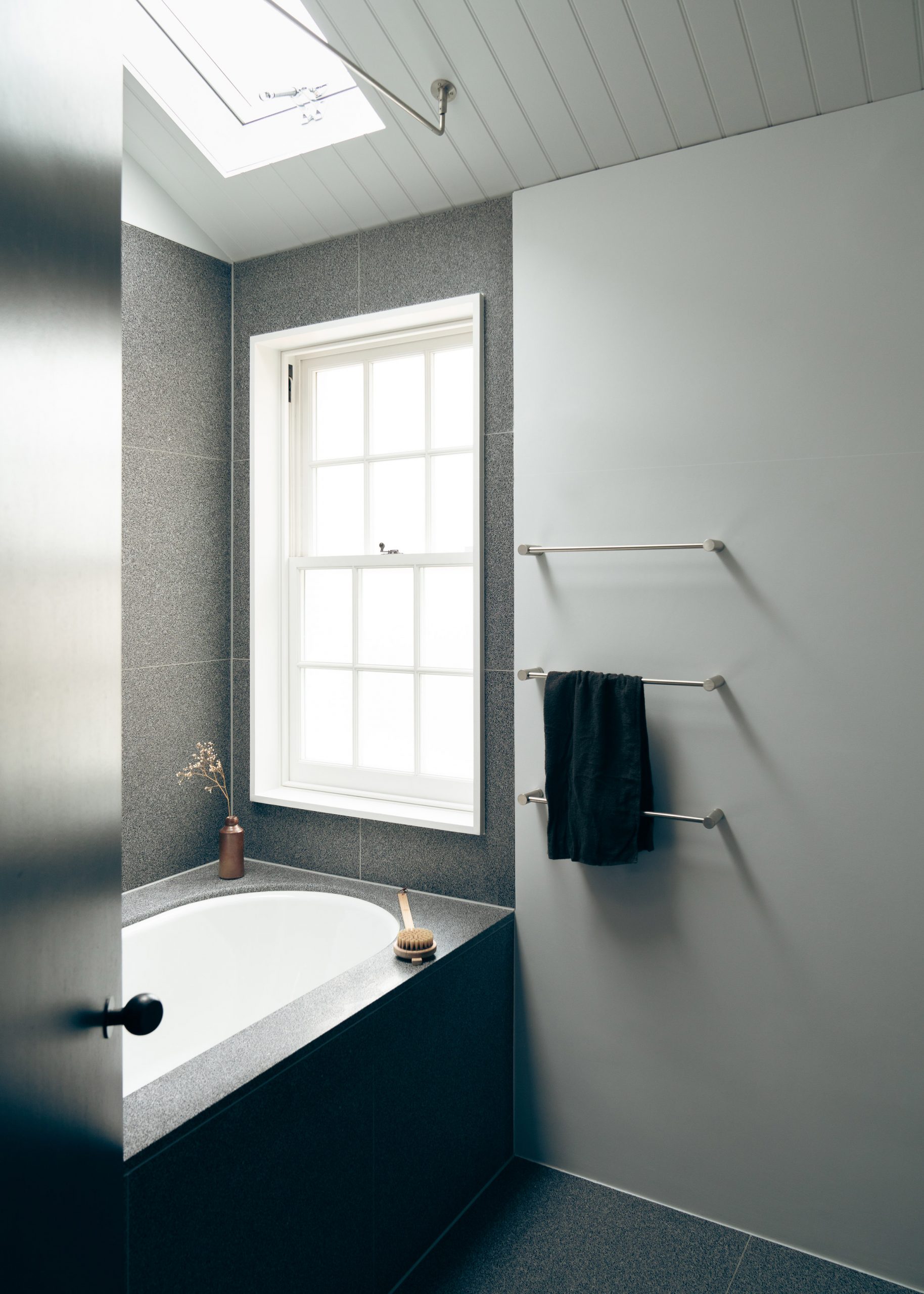 The bathroom in Concrete Plinth House employs a dark grey palette