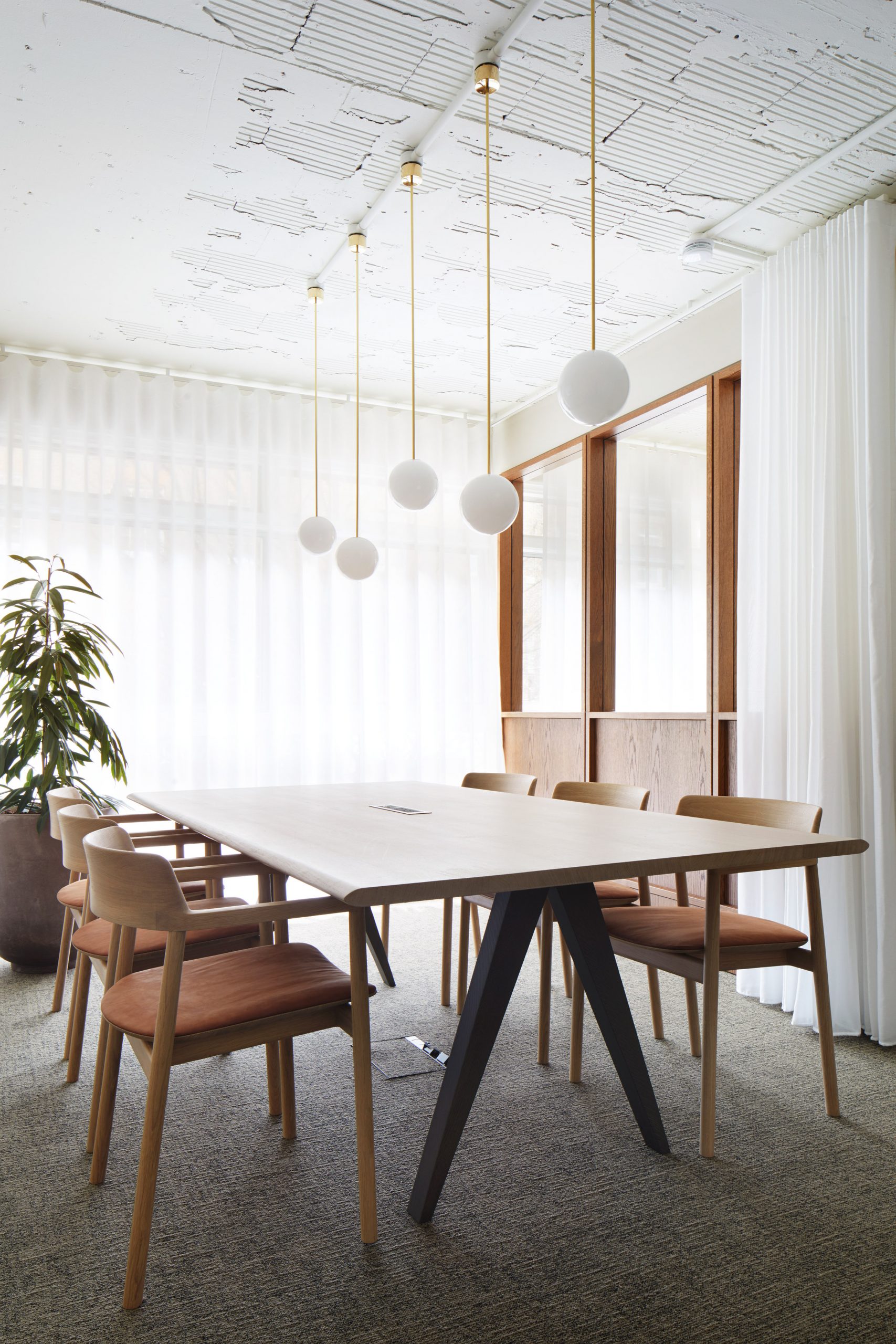 Wood-panelled meeting room with spherical pendant lights and wooden furniture in Fitzroy Street office interior