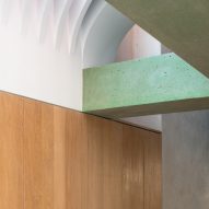 Wood panelled walls meet green concrete beams