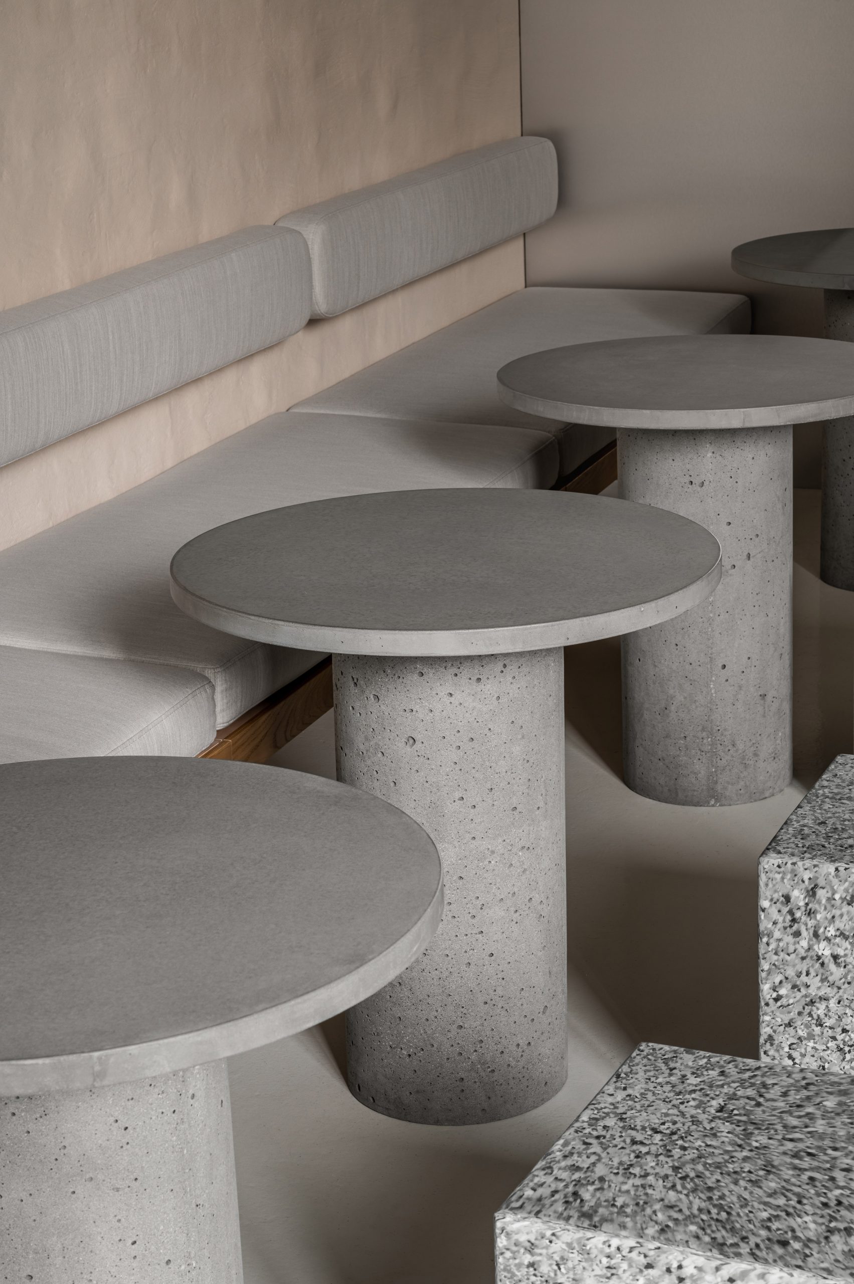 Round concrete tables and bench seating in IteIstetyka restaurant