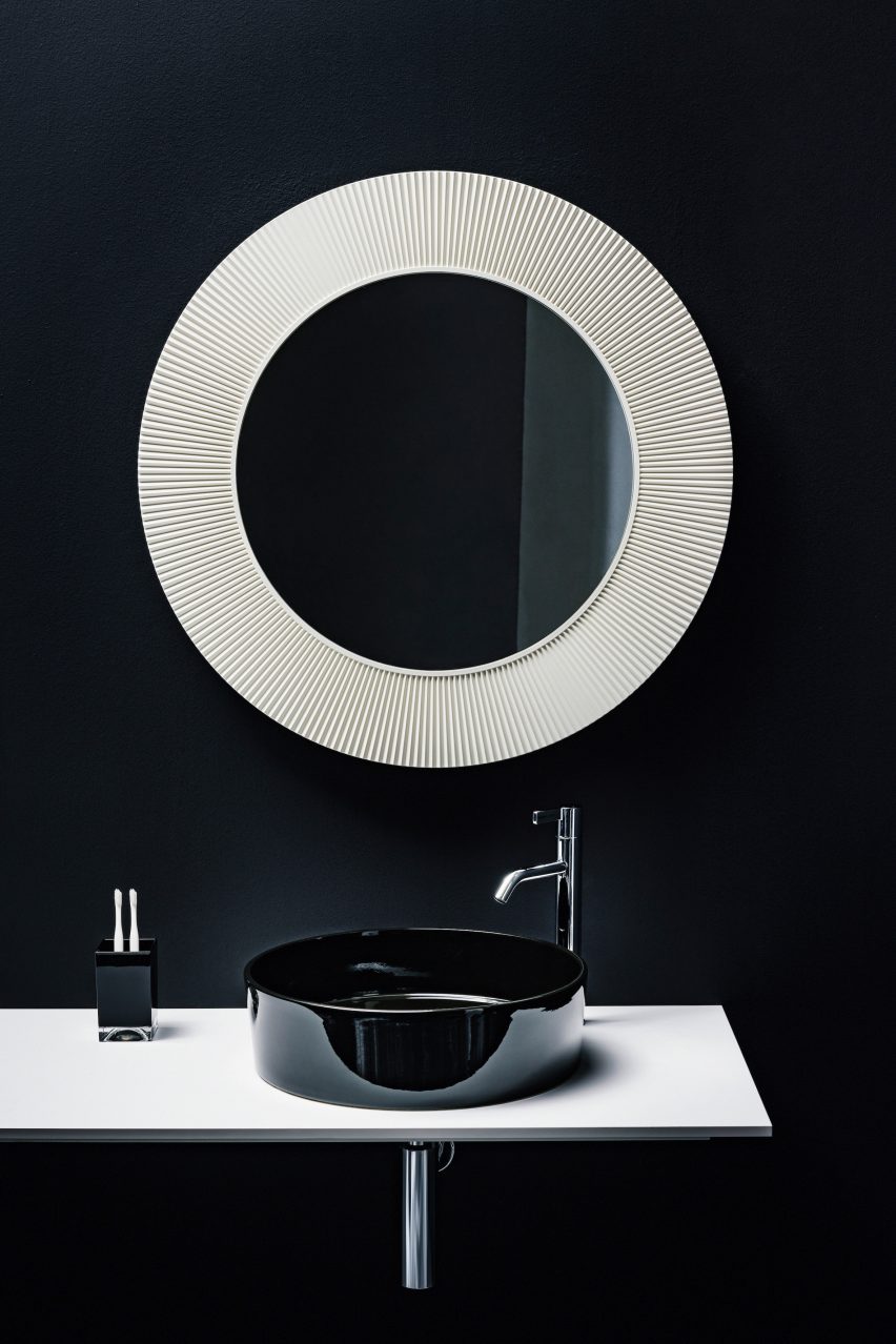 A circular bathroom mirror and sink