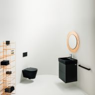 A white bathroom with a black sink and toilet