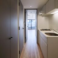A galley kitchen is located between living spaces