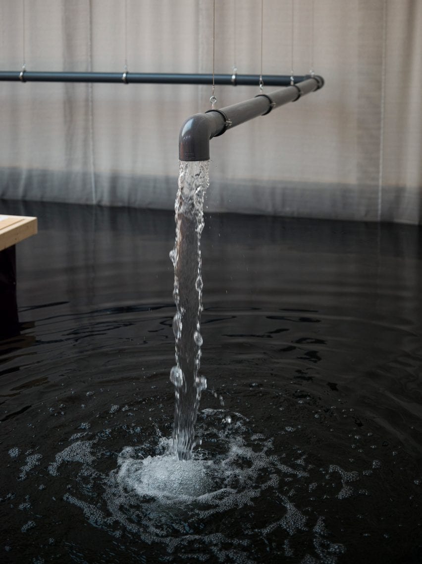 A PVC pipe is suspended over the body of water