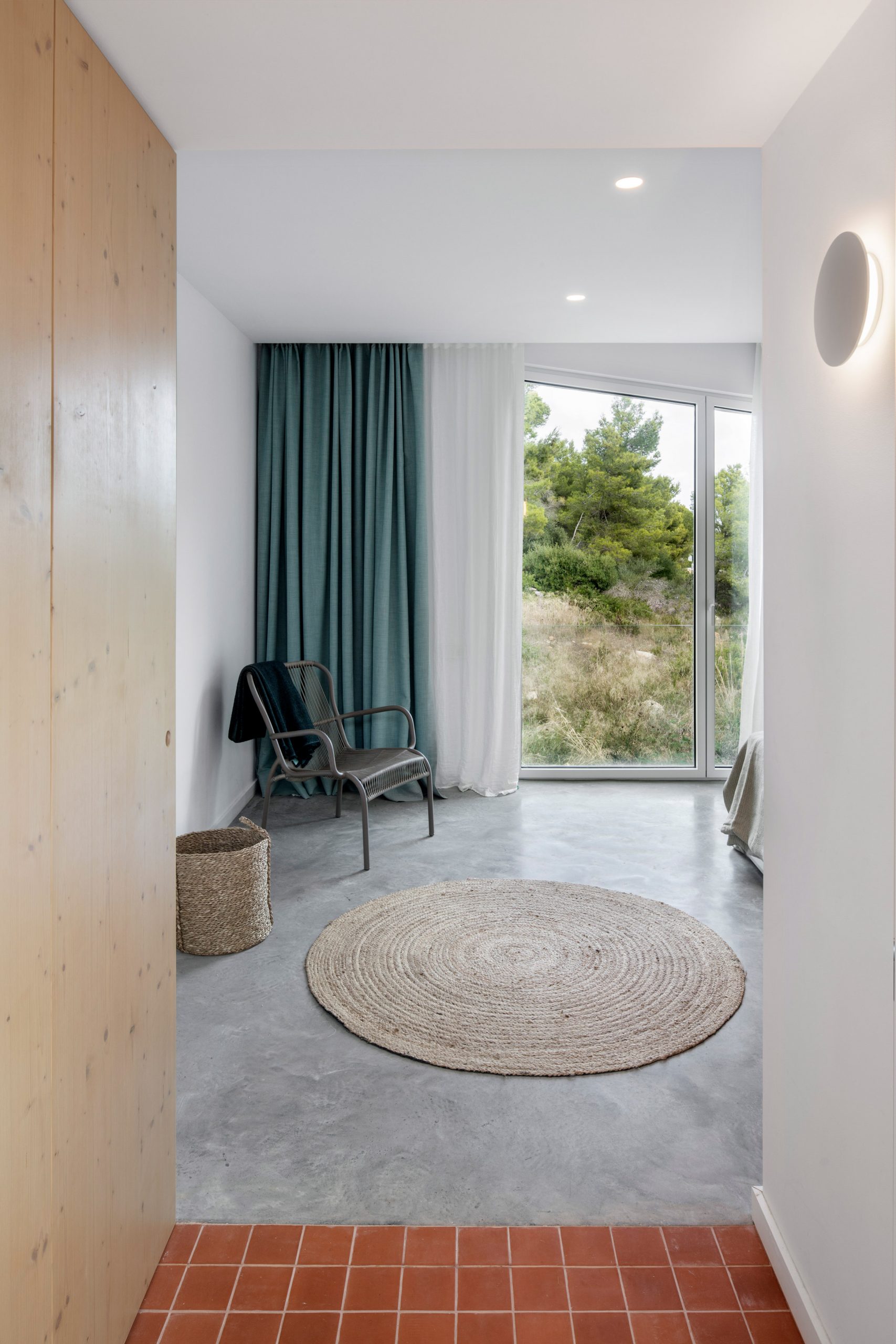 Terracotta tiles and concrete cover the floors at Curved House