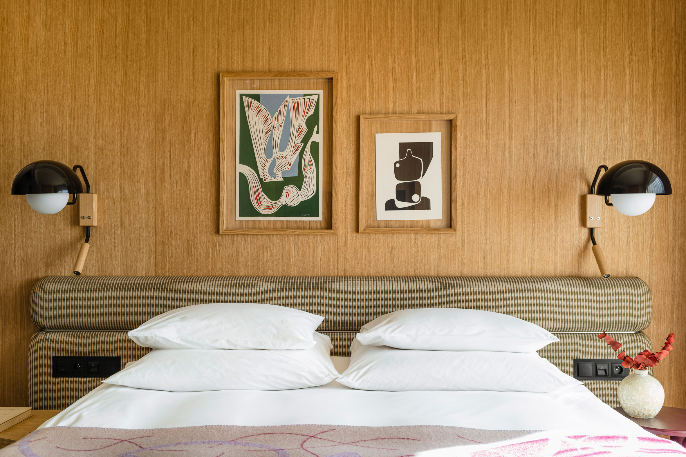 Bedroom with wooden wall panelling in hotel interior by Studio Paradowski