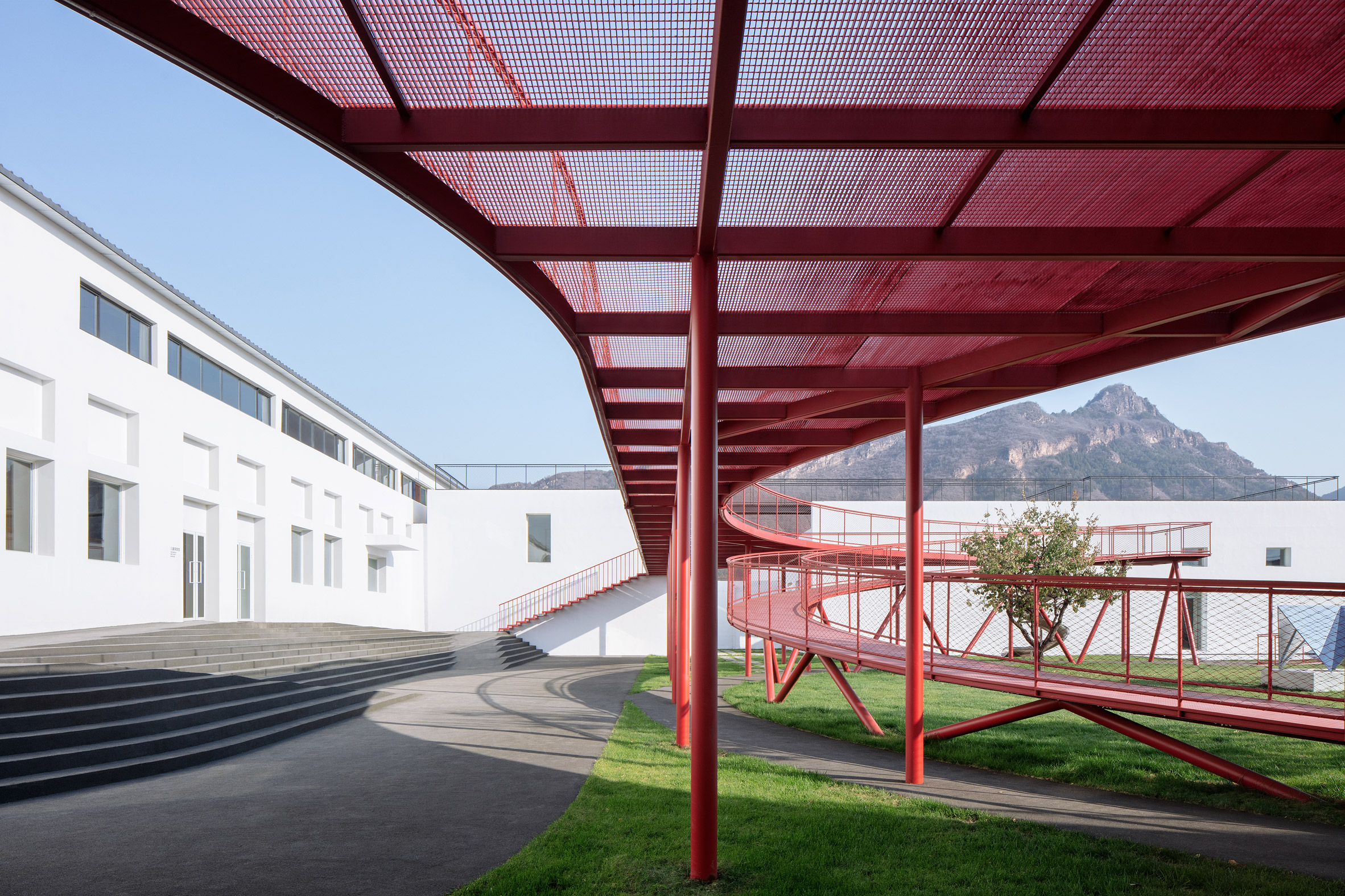A red steel walkway in a courtyard