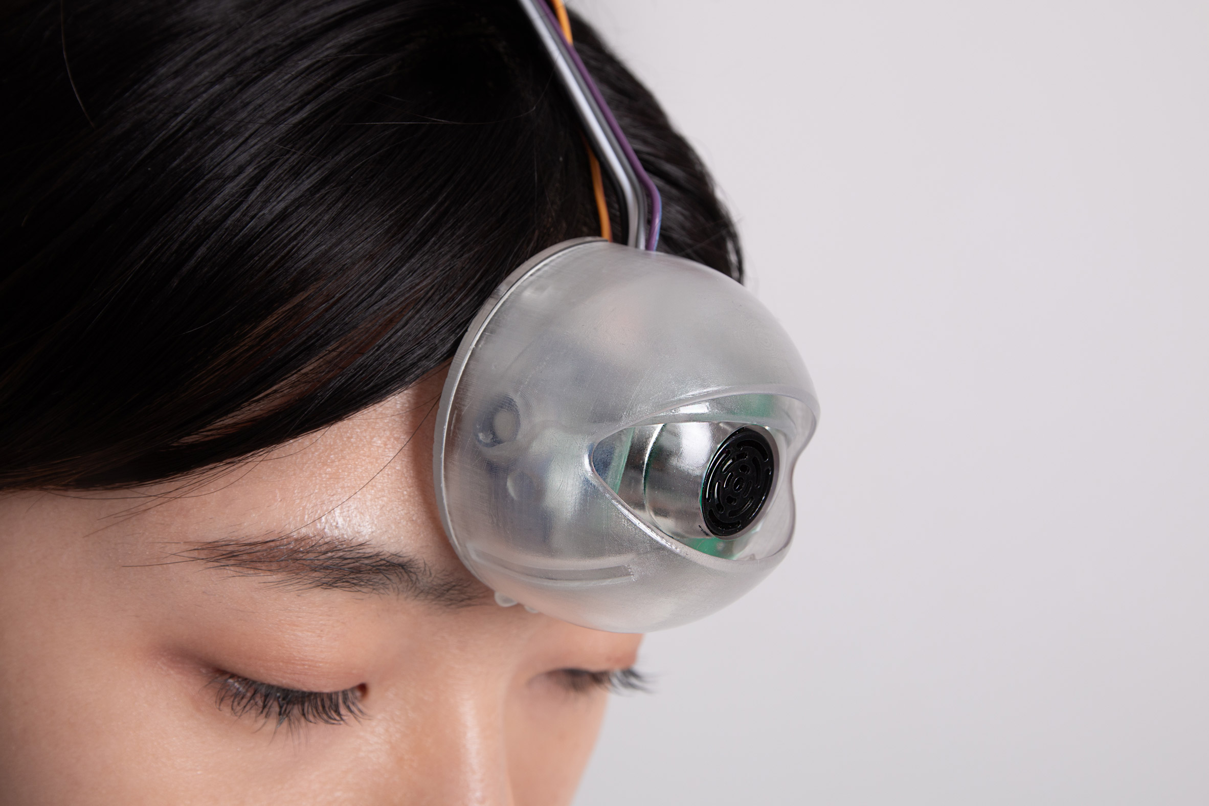 Close-up of robotic eye by Minwook Paeng on a woman's forehead