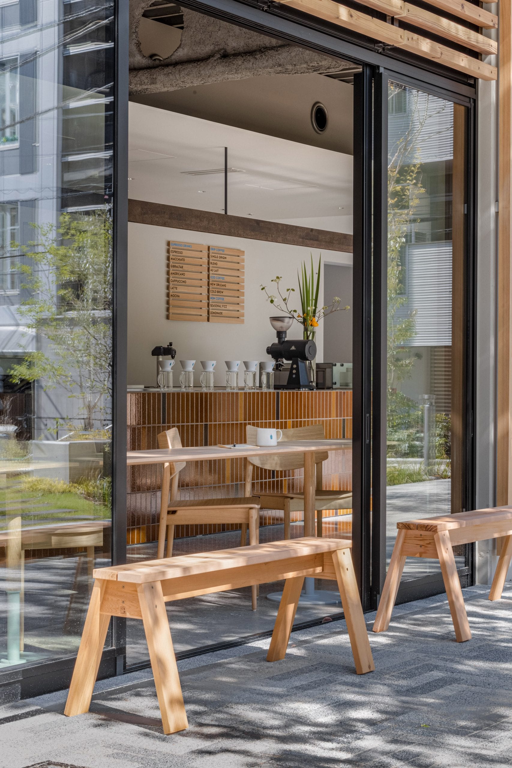 Wooden benches outside coffee shop by Keiji Ashizawa Design