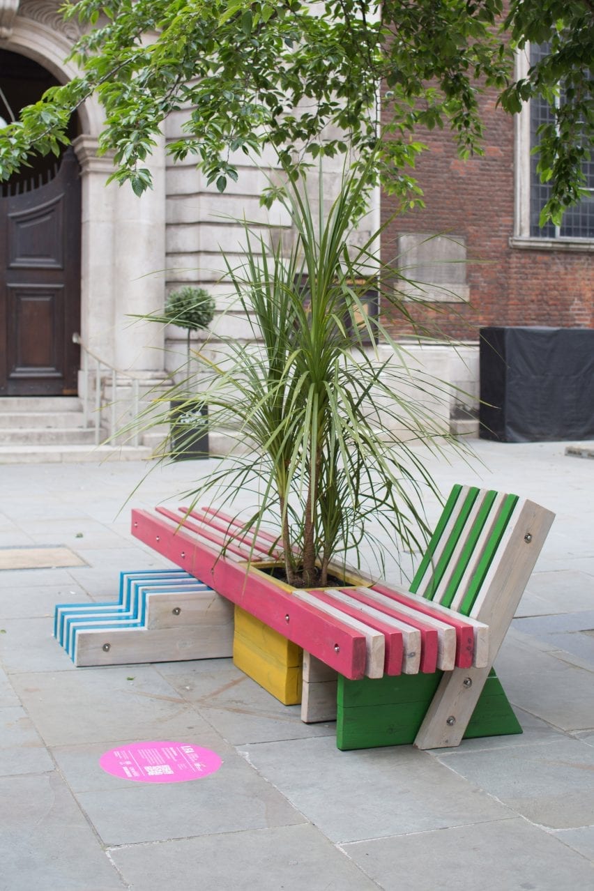 A wooden bench with a central planter