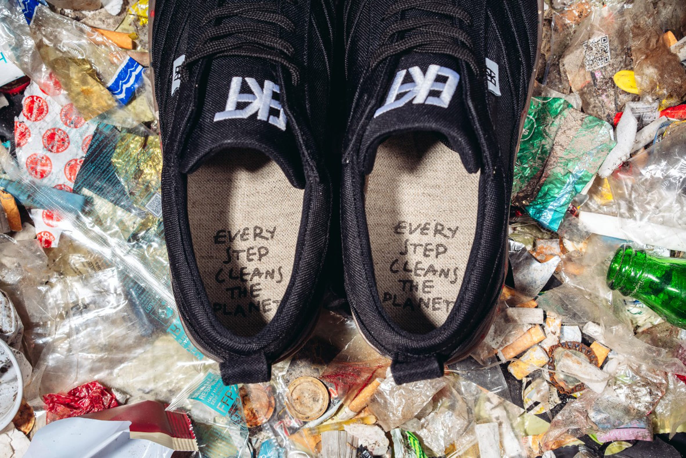 A pair of trainers with the phrase "Every step cleans the planet" written inside