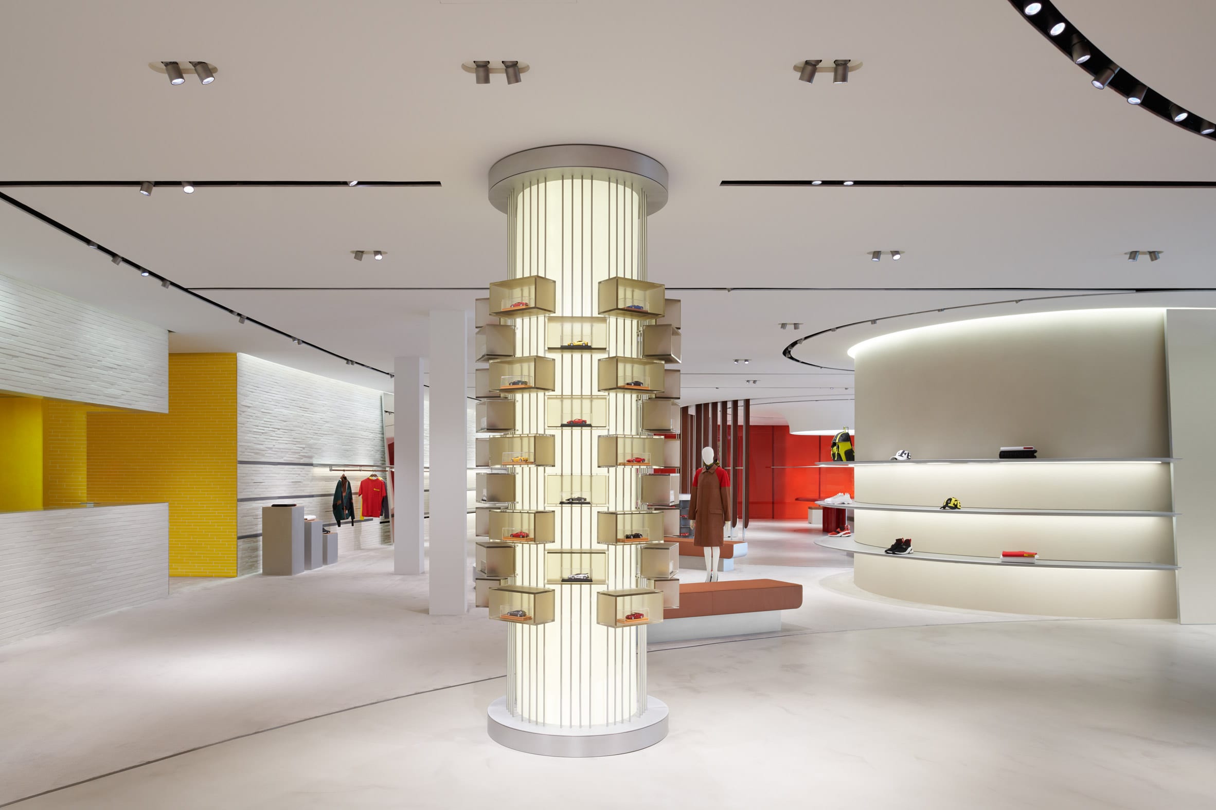 Cylindrical column displaying miniature Ferrari care in Maranello store interior