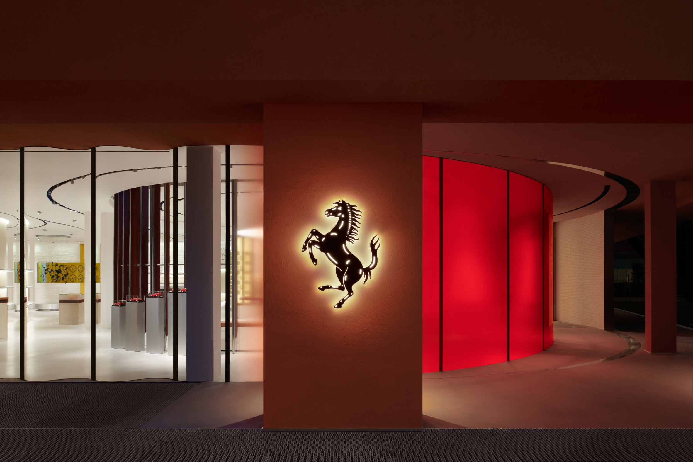 Exterior of Ferrari Maranello store with illuminated prancing horse logo
