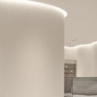 Curving walls are illuminated by strip lights