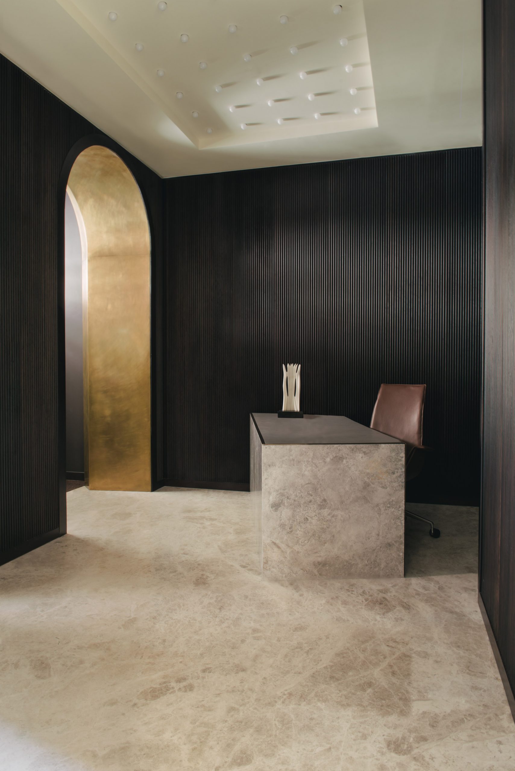 Lobby of Mandeville Place office with textured black walls, marble flooring and gold entryway