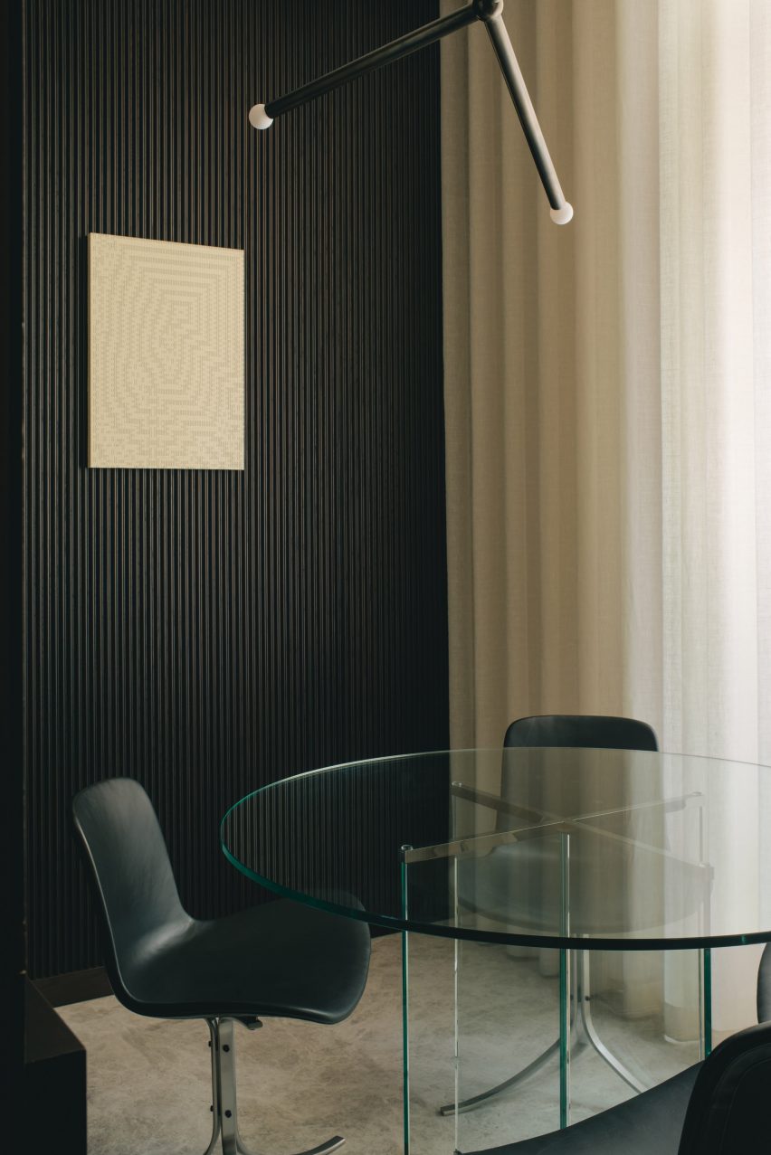 Glass table with black chairs and black panelled walls in Mandeville Place office