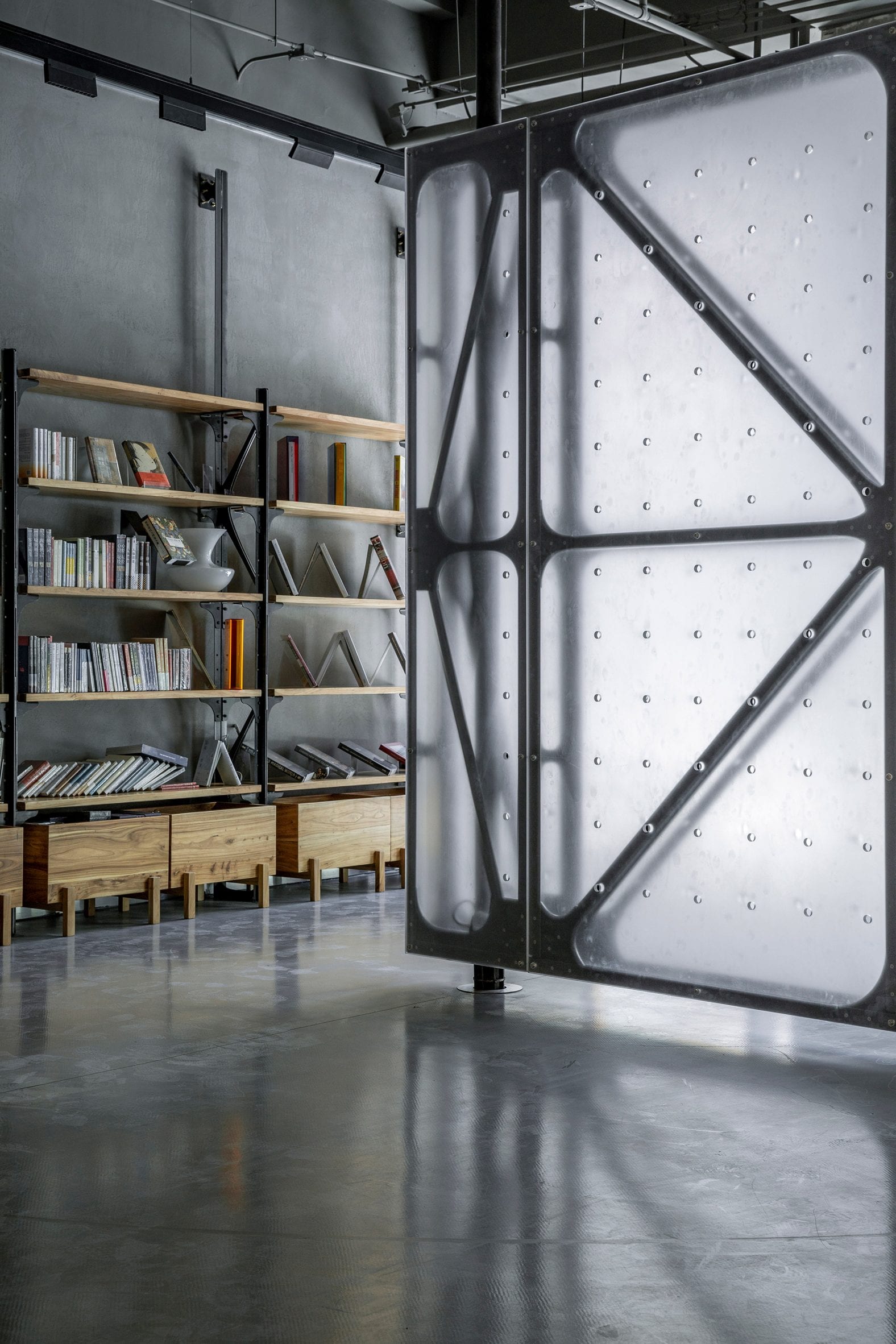 Translucent rotating wall next to bookshelf in Mumokuteki Concept Bookstore