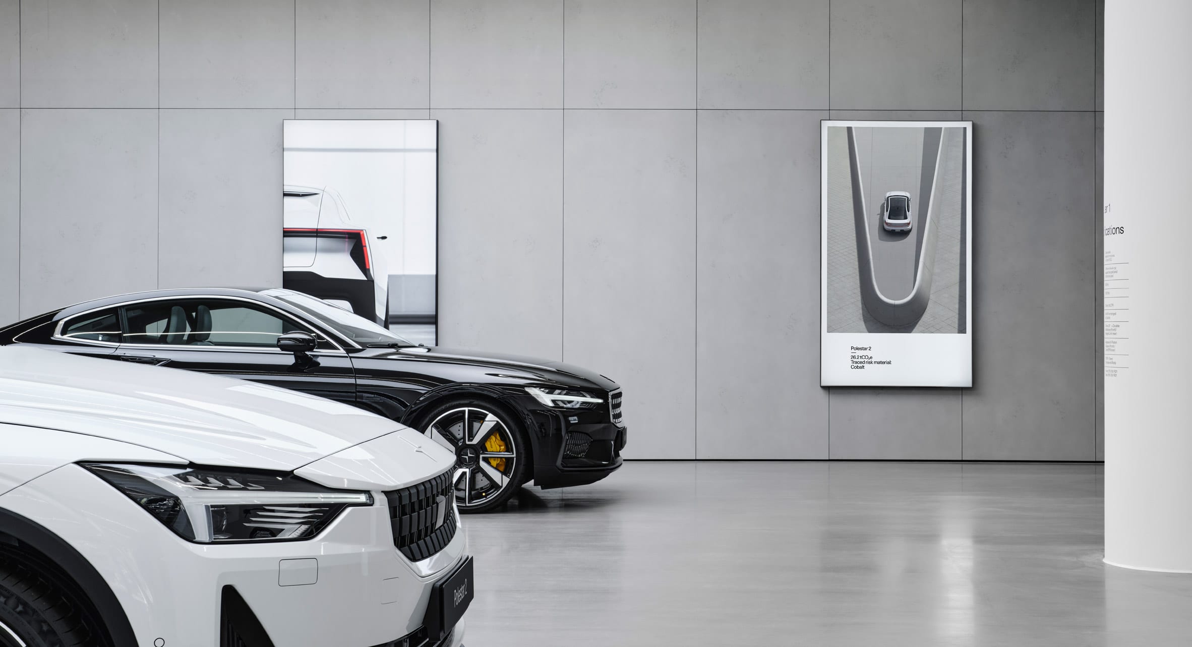 Polestar 2 cars in a dealership with poster about associated CO2 emissions