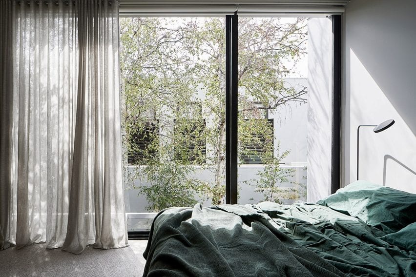 Kamar tidur dengan jendela dari lantai ke langit-langit dan tempat tidur hijau di kediaman Cunningham Street