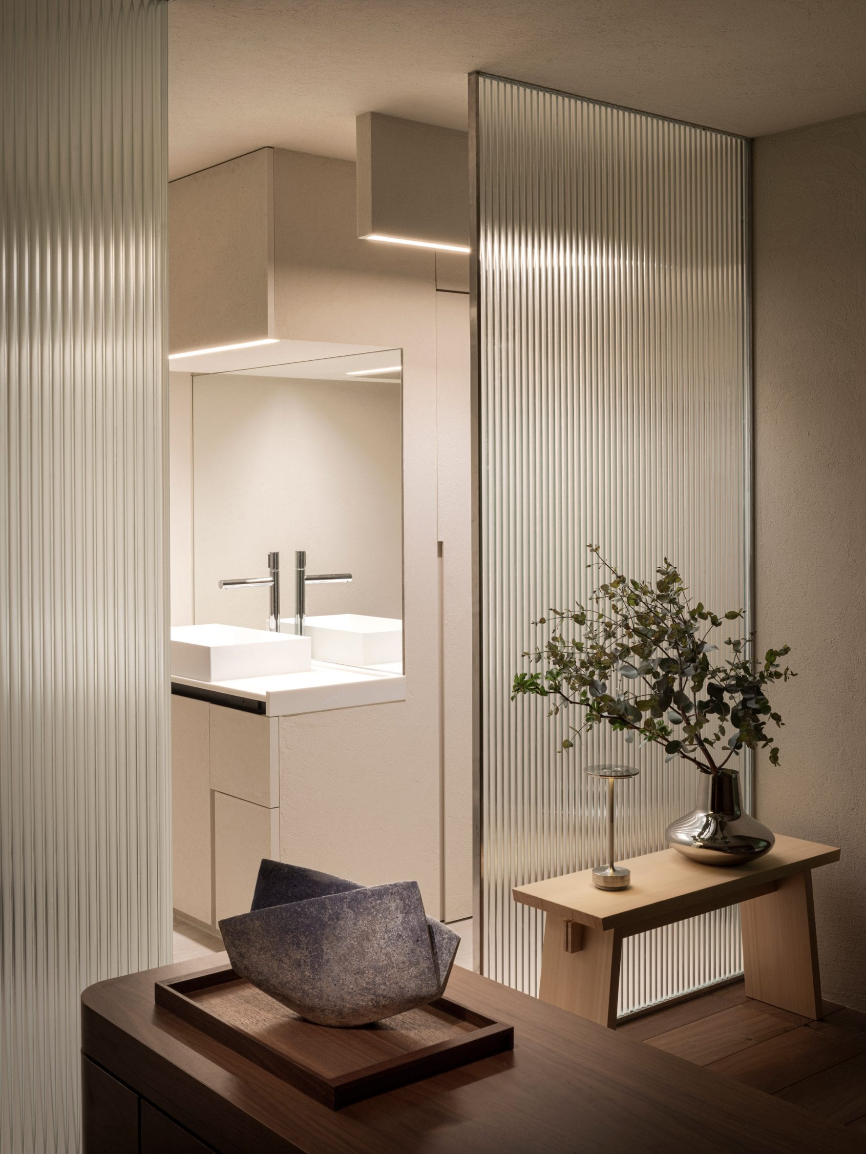 Bathroom entrance with glass walls and decorative vases in The Life concept apartment