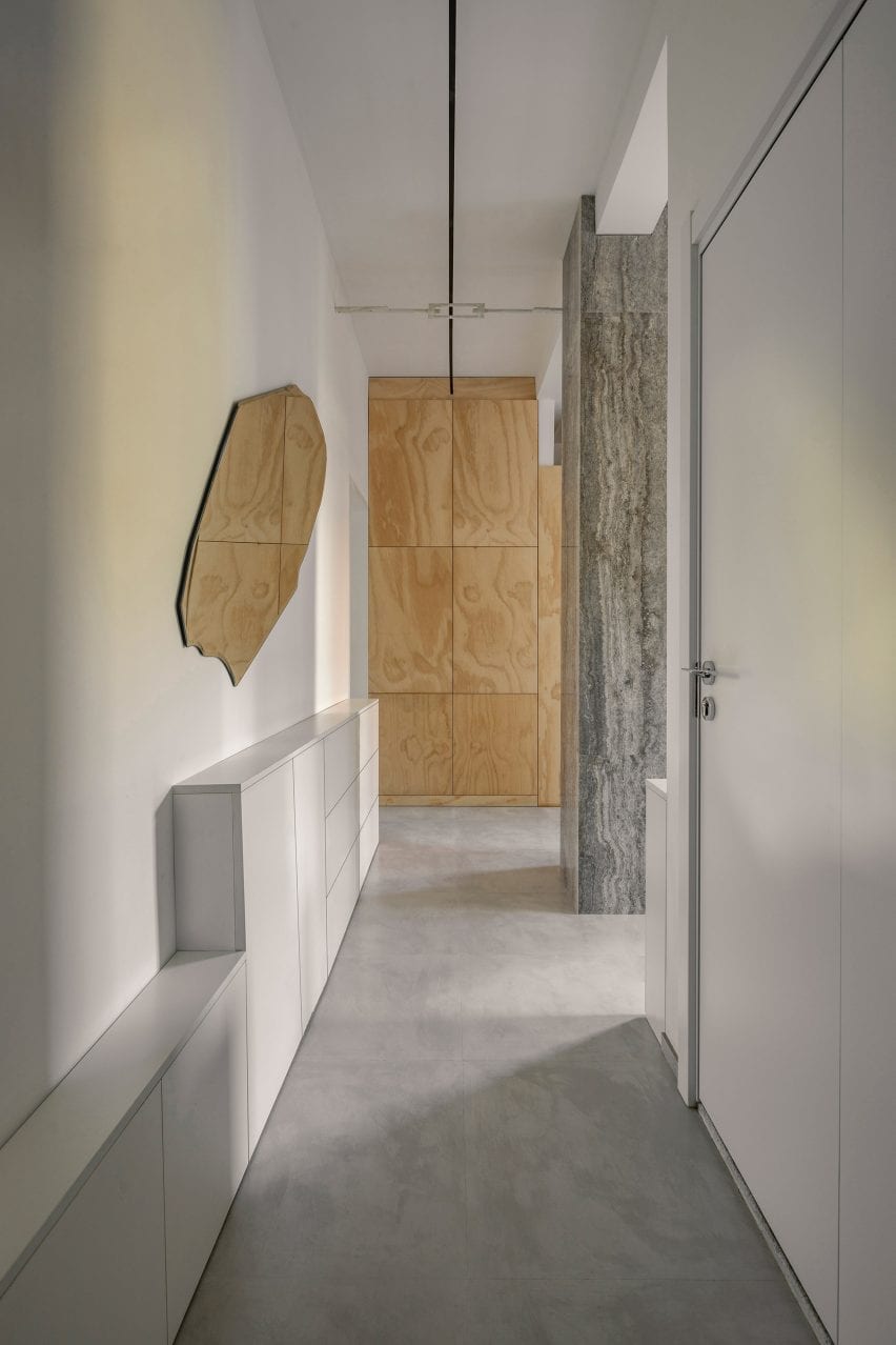 Pintu masuk dengan lantai beton, dinding putih dan sambungan kayu lapis di apartemen pasca-perang Beijing