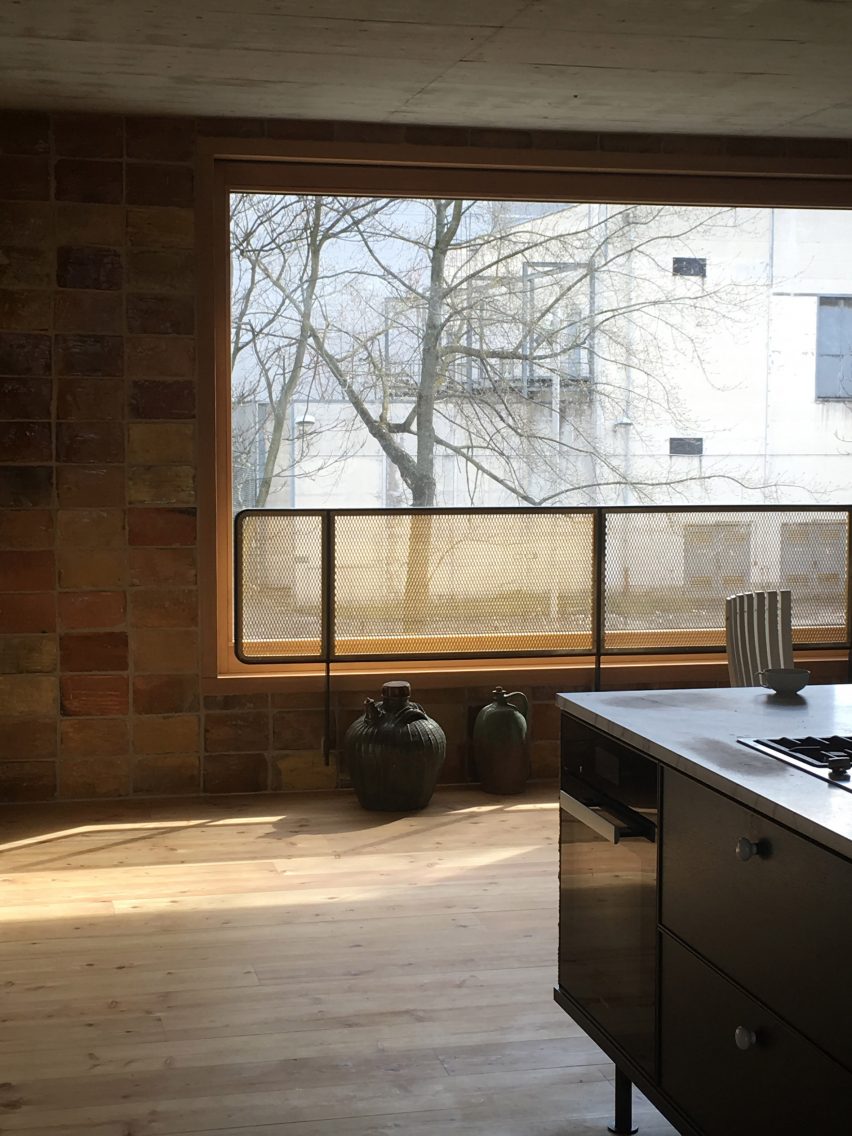 Cozinha com paredes de tijolos e piso de madeira no interior por Philipp von Matt