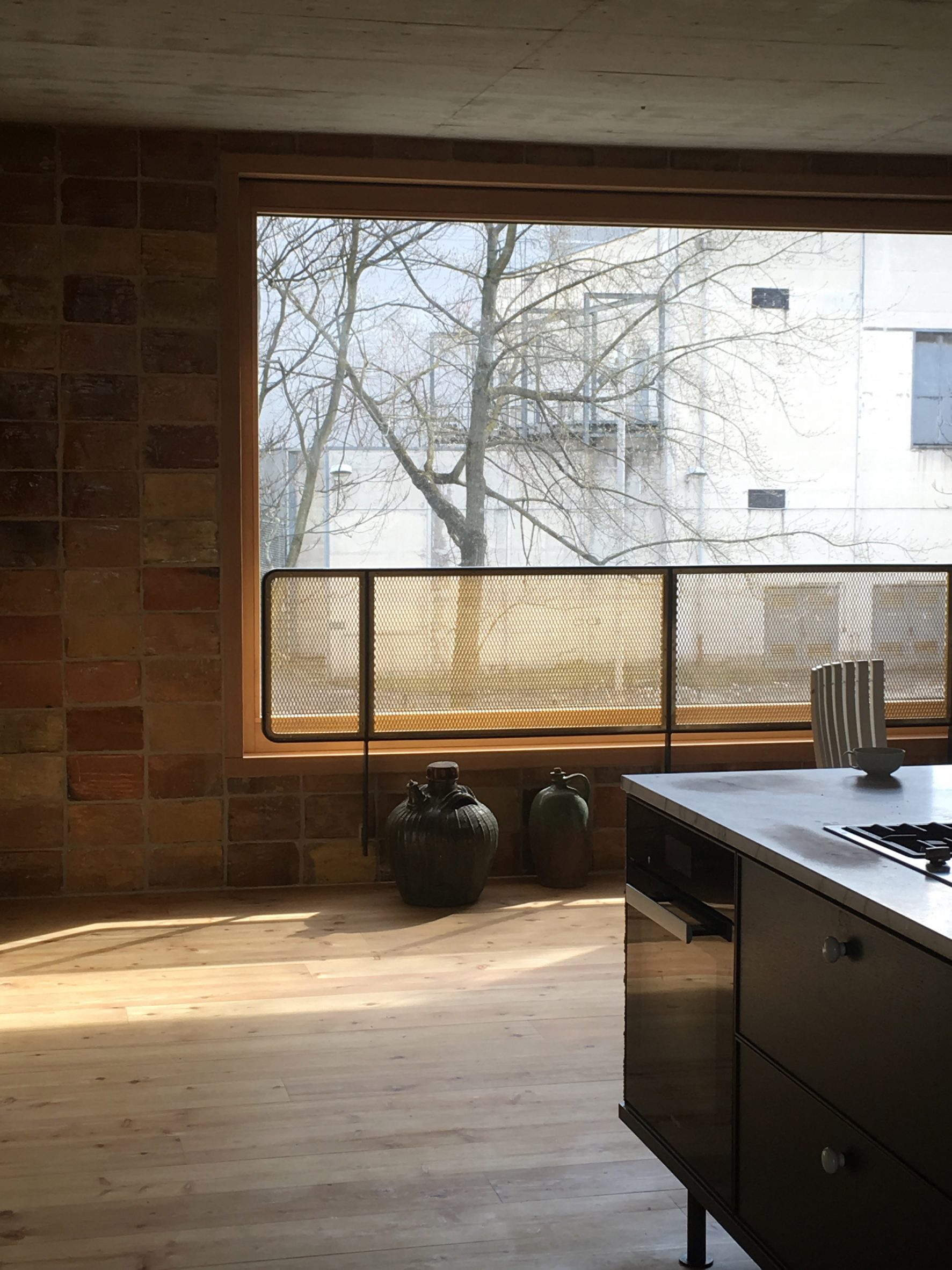 Kitchen with brick walls and wooden floors in interior by Philipp von Matt