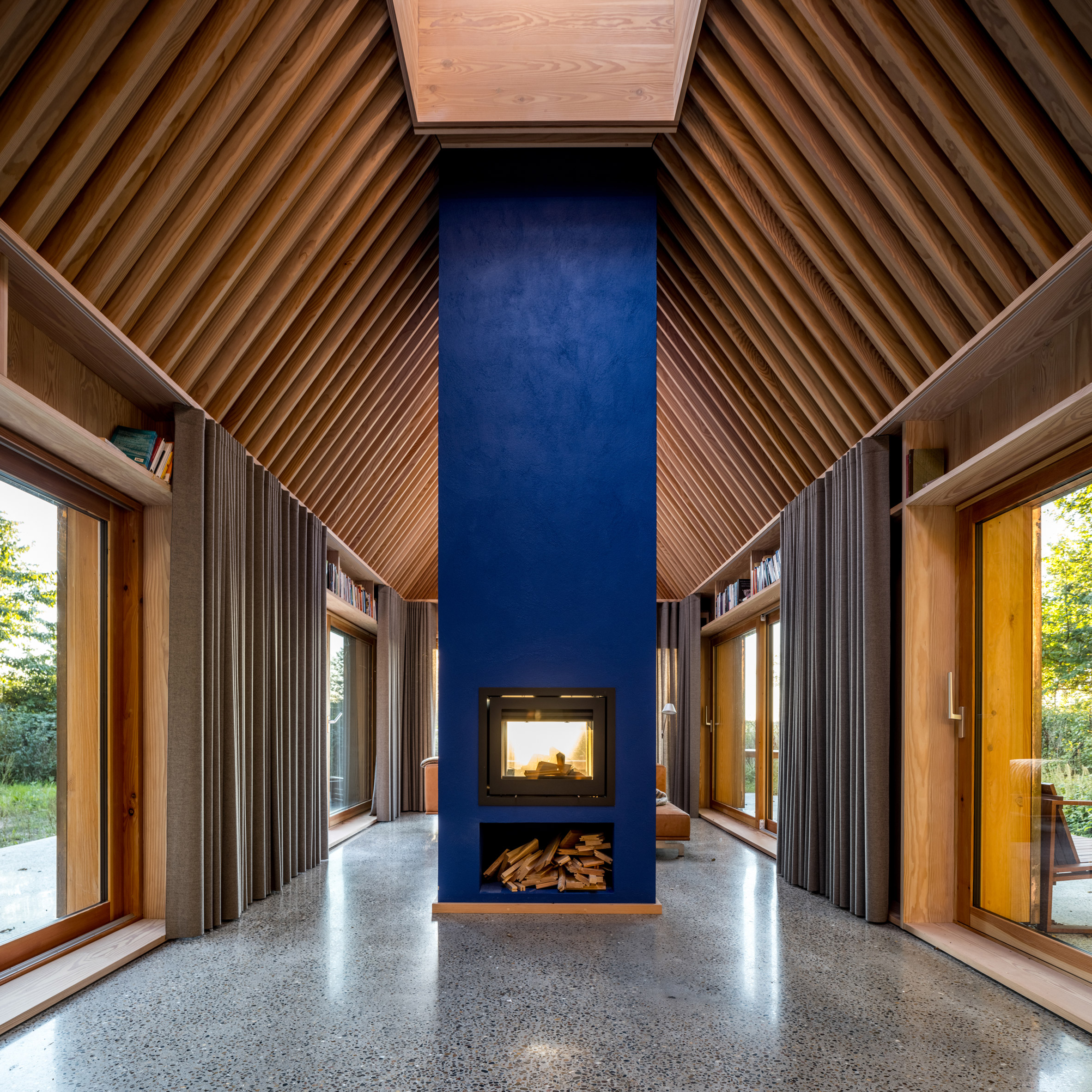 Blue hearth and timber ceiling beams inside The Author's House by Sleth
