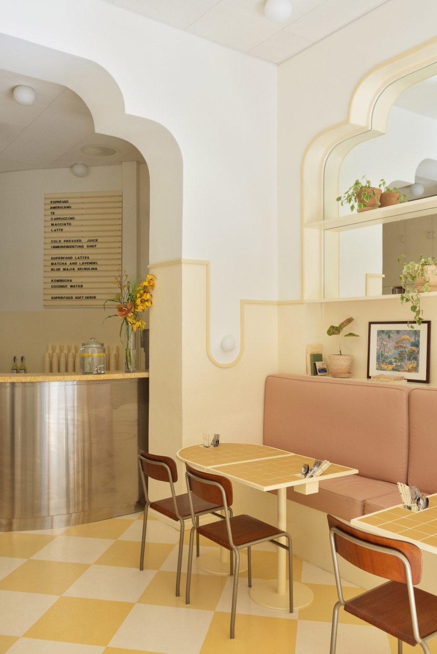 Seats and yellow custom-made tables in cafe inspired by Wes Anderson