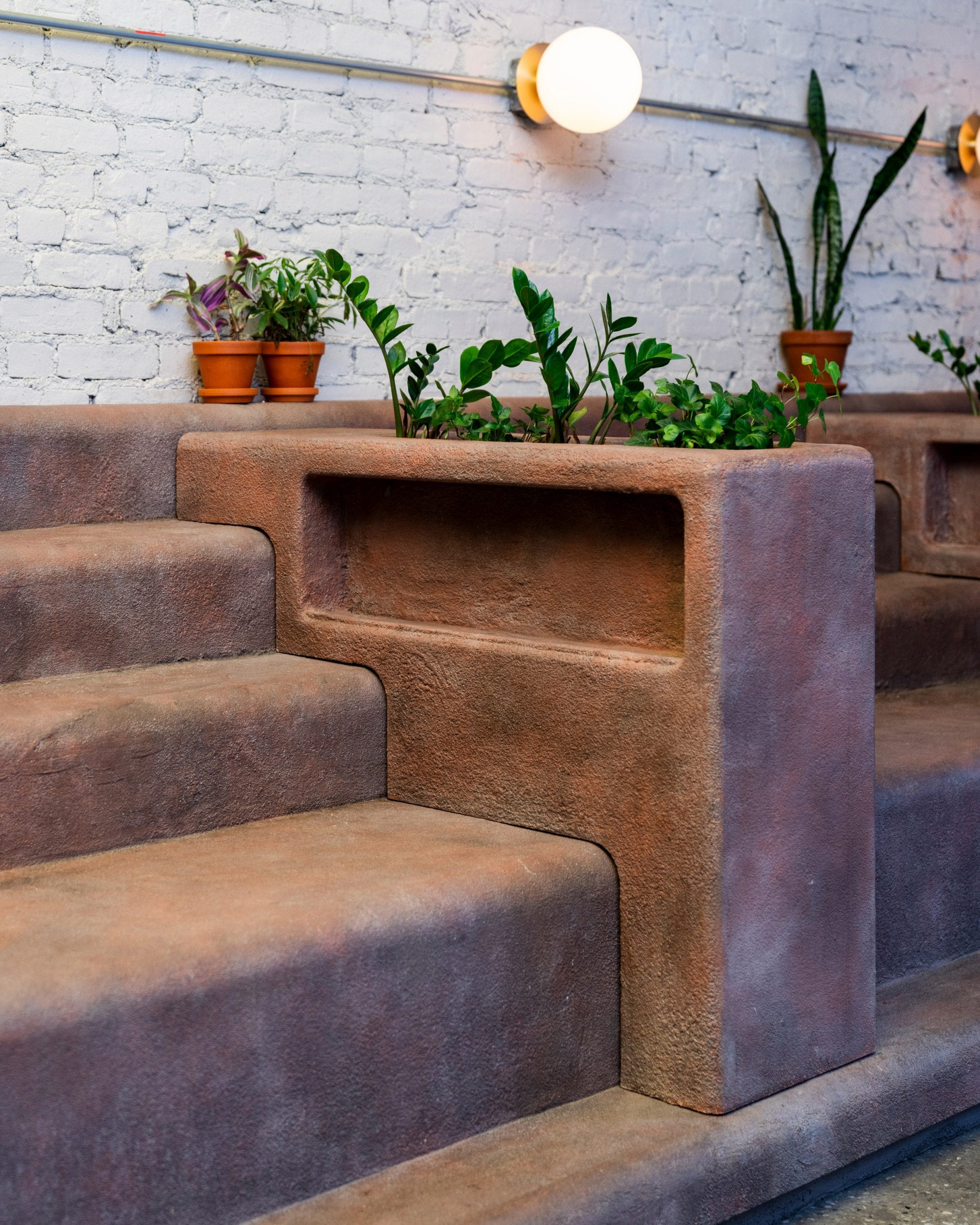 Planters sit between the stooped seating in Daughter