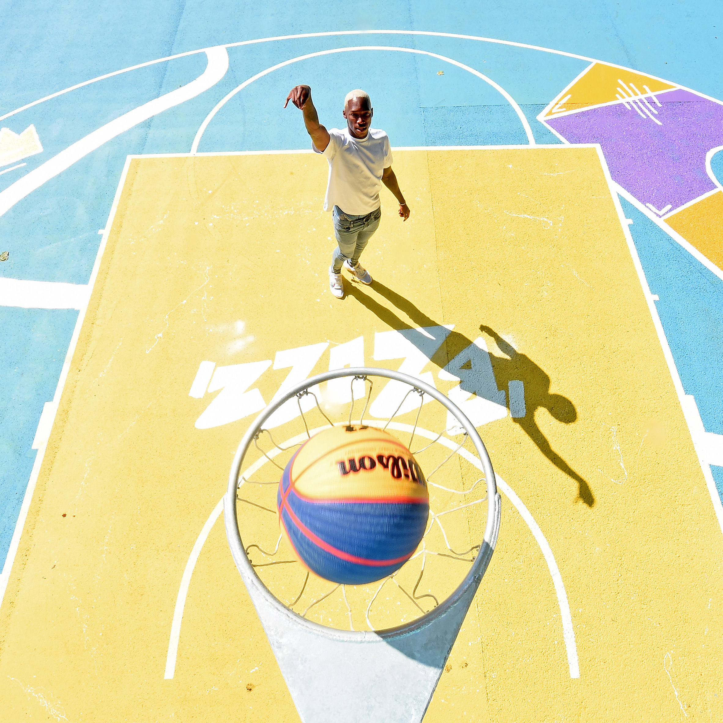 a man shoots a ball into a hoop on a basketball court