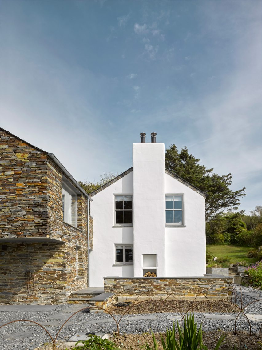 A white house with a stone extension