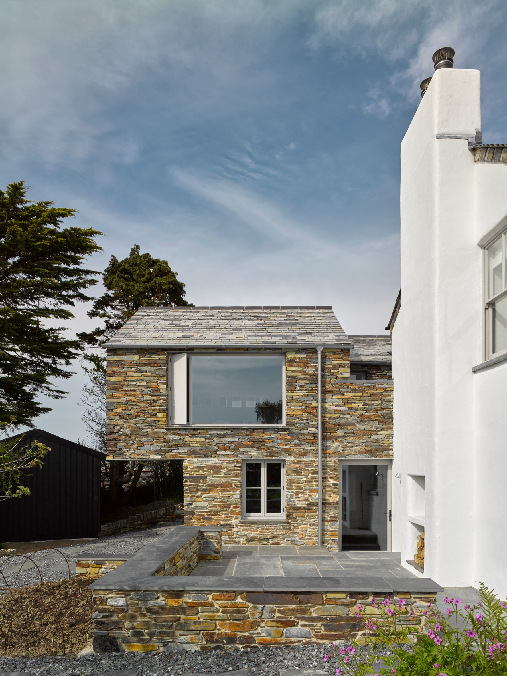 A stone extension to a white house