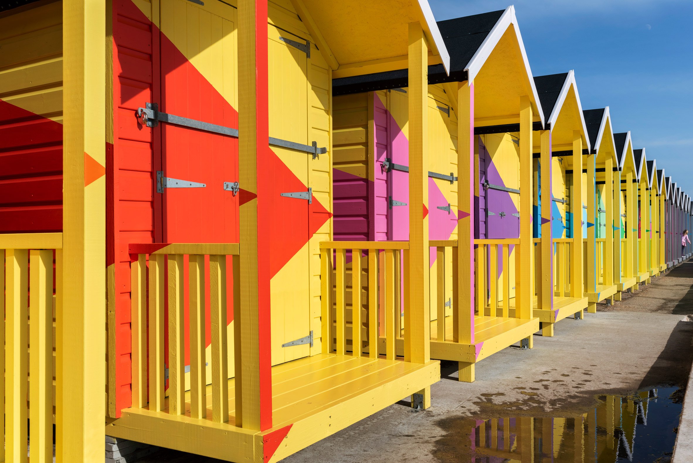 Yellow beach huts with colourful triangles by Rana Begum at Folkestone Triennial 2021