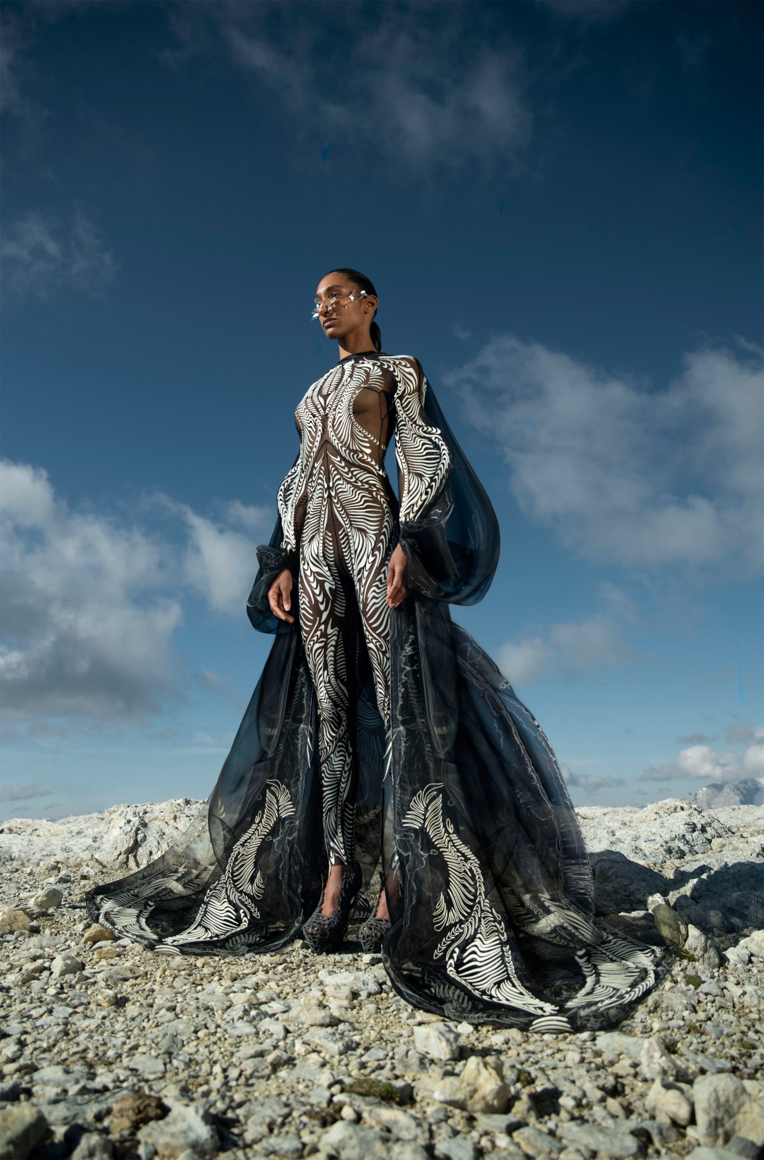 A woman standing on rocks in a look from the Earthrise collection