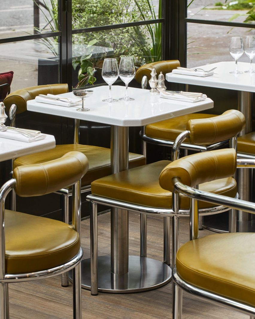 Baja berbentuk tabung dan kursi kulit hijau di interior restoran Abstinence