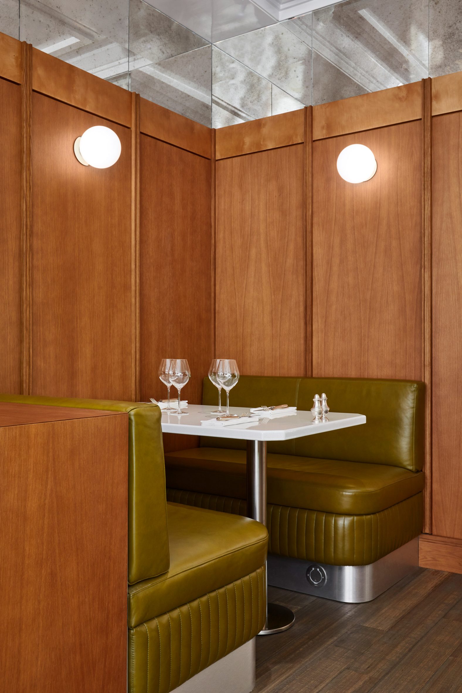 Wood panelling with leather booth and spherical lights in restaurant interior by Lizée-Hugot